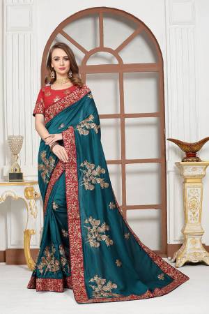 Get Ready For The Upcoming Festive And Wedding Season With This Heavy Designer Saree In Teal Blue Color Paired With Red Colored Blouse. This Saree Is Fabricated On Chiffon Satin Paired With Art Silk Fabricated Blouse. It Is Beautified With Attractive Embroidery With Heavy embroidered Lace Border. 