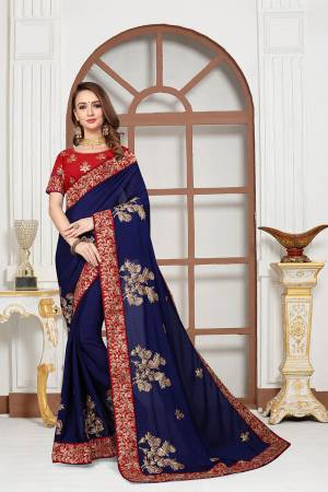 Get Ready For The Upcoming Festive And Wedding Season With This Heavy Designer Saree In Royal Blue Color Paired With Red Colored Blouse. This Saree Is Fabricated On Chiffon Satin Paired With Art Silk Fabricated Blouse. It Is Beautified With Attractive Embroidery With Heavy embroidered Lace Border. 