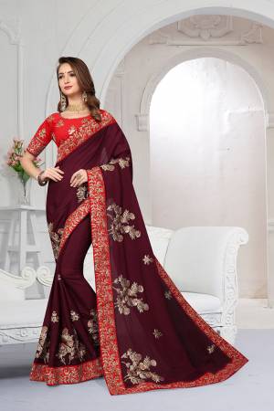 Get Ready For The Upcoming Festive And Wedding Season With This Heavy Designer Saree In Burgundy Color Paired With Red Colored Blouse. This Saree Is Fabricated On Chiffon Satin Paired With Art Silk Fabricated Blouse. It Is Beautified With Attractive Embroidery With Heavy embroidered Lace Border. 