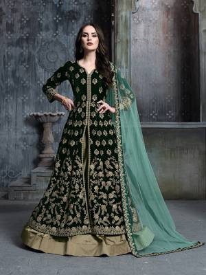 Here Is A Very Pretty Designer Indo-Western Suit In Dark Green Colored Top Paired With Beige Colored Bottom And Light Green Colored Dupatta. Its Heavy Embroidered Top Is Fabricated On Velvet Paired With Tafeta Art Silk Bottom And Net Fabricated Dupaata. Buy This Lehenga Suit Now.