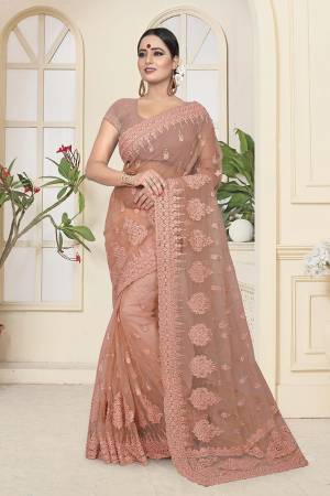 Get Ready For The Upcoming Wedding Season With This Heavy Designer Saree In Dusty Peach Color Which Is Most Trending Color OF The Season. This Saree And Blouse Are Fabricated On Net Beautified With Heavy Tone To Tone Resham and Ceramic Stone Work