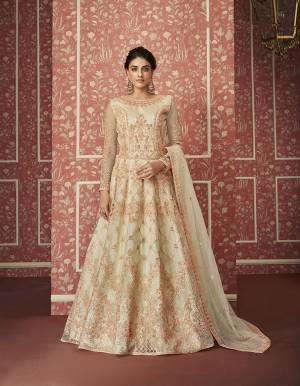 Catch All The Limelight This Wedding Season Wearing This Heavy Designer Floor Length Suit In Cream Colored Top, Bottom And Dupatta. Its Heavy Embroidered Top Is Fabricated On Net Paired With Satin Bottom and Net Fabricated Dupatta. Its Pretty Embroidery Gives A Heavy And Subtle Look Both At The Same Time. Buy Now.