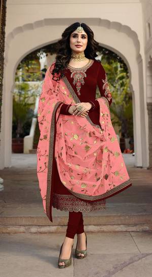 Grab This Heavy Designer Straight Cut Suit With Pretty Attractive Dupatta. This Suit Is In Maroon Color Paired With Contrasting Peach Colored Dupatta. Its Top Is Fabricated On Satin Georgette Paired With Santoon Bottom And Georgette Fabricated Dupatta. It Is Beautified With Heavy Embroidery Over Top And Dupatta. 