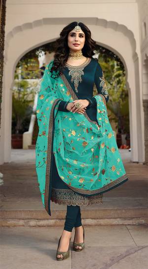 Grab This Heavy Designer Straight Cut Suit With Pretty Attractive Dupatta. This Suit Is In Teal Blue Color Paired With Contrasting Sea Green Colored Dupatta. Its Top Is Fabricated On Satin Georgette Paired With Santoon Bottom And Georgette Fabricated Dupatta. It Is Beautified With Heavy Embroidery Over Top And Dupatta. 