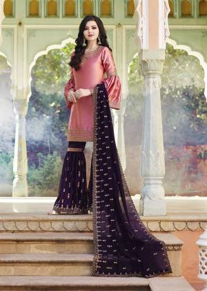 You Will Definitely Earn Lots Of Compliments Wearing This Pretty Girly Color Pallete In Pink Colored Top Paired With Contrasting Dark Purple Colored Bottom And Dupatta. This Heavy Embroidered Sharara Suit Is Fabricated On Satin Paired With Georgette Fabricated Dupatta. 