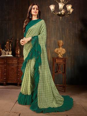 Celebrate This Festive Season With This Treding Ruffle Saree In Light Green Color Paired With Dark Green Colored Blouse. This Saree And Blouse Are Silk Based Beautified With Checks Prints And Ruffle Border. Buy Now.