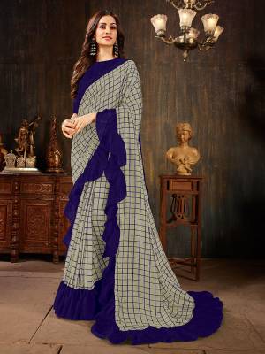 Celebrate This Festive Season With This Treding Ruffle Saree In Grey Color Paired With Navy Blue Colored Blouse. This Saree And Blouse Are Silk Based Beautified With Checks Prints And Ruffle Border. Buy Now.