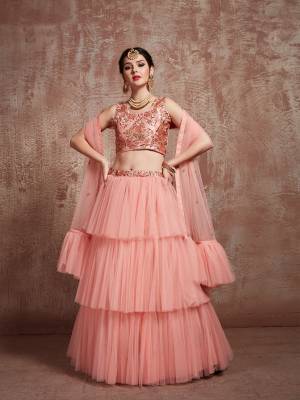 Here Is A Very Pretty Designer Lehenga Choli For The Upcoming Wedding Season In Lovely Peach Color. Its Embroidered Blouse Is Satin Based Paired With Net Fabricated Lehenga And Dupatta. Its Pretty Leyered Lehenga Will Give An Attractive Look To Your Personality. 