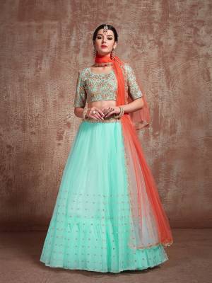 Catch All The Limelight At The Next Wedding You Attend Wearing This Designer Lehenga Choli In Aqua Blue Color Paired With Contrasting Orange Colored Dupatta. Its Blouse Is Art Silk Based Paired With Net Fabricated Lehenga And Dupatta. 