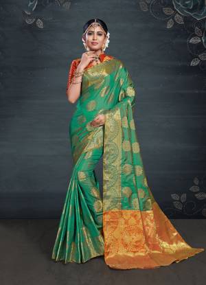 Catch All The Limelight At The Next Function You Attend Wearing This Silk Based Saree In Green Color Paired With Contrasting Orange Colored Blouse. Its Rich Banarasi Art Silk Fabric Will Give A Royal Look To Your Personality. 