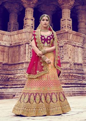 For The Brides Who Like To Experiment With New Color With New Trend, Here Is Prefect Bridal Lehenga Choli Those. Its Pretty Blouse Is In Purple Color Paired With Peach Colored Lehenga And Dark Pink Colored Dupatta. Its Blouse And Lehenga Are Fabricated On Nylon Satin Paired With Net Fabricated Dupatta. 