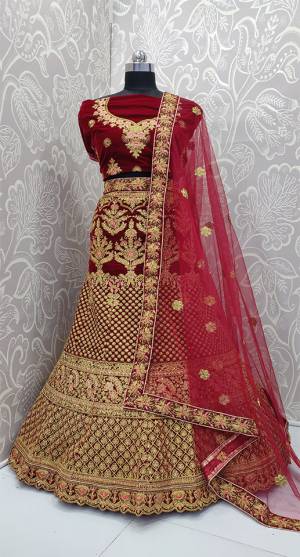 Here Is A Very Beautiful And Heavy Bridal Designer Lehenga Choli In Maroon Color. Its Blouse And Lehenga Are Fabricated On Velvet Paired With Net Fabricated Dupatta. It Is Beautified With Heavy Embroidery Which Gives An Attractive Look To It.