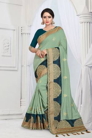 Get Ready For The Upcoming Wedding And Festive Season With This Designer Saree In Pastel Green Color Paired With Contrasting Teal Blue Colored Blouse. This Embroidered Saree Is Fabricated On Vichitra Silk Paired With Tafeta Art Silk Fabricated Blouse. 