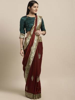 This Festive Season Have A Proper Traditonal Look With This Silk Based Embroidered Saree. This Saree Is In Maroon Color Paired With Contrasting Teal Blue Colored Blouse. It Is Beautified With Lace Border & Embroidered Butti.