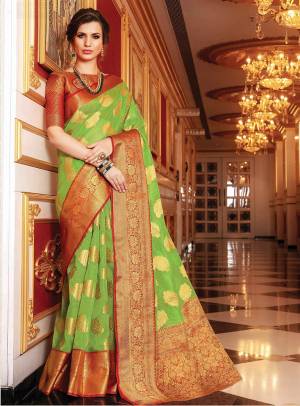 Catch All The Limelight At The Next Function You Attend Wearing This Silk Based Saree In Light Green Color Paired With Contrasting Orange Colored Blouse. Its Rich Handloom Art Silk Fabric Will Give A Royal Look To Your Personality
