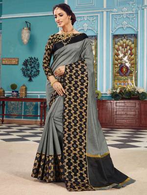 Here Is A Pretty Silk Based Saree In Same Family Color Saree And Blouse. This Pretty Saree Is In Grey Color Paired With Black Colored Blouse. It Is Beautified With Weave Over The Broad Saree Border Giving It An Attractive Look. 