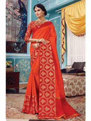 Here Is A Pretty Silk Based Saree In Same Family Color Saree And Blouse. This Pretty Saree Is In Orange Color Paired With Red Colored Blouse. It Is Beautified With Weave Over The Broad Saree Border Giving It An Attractive Look. 