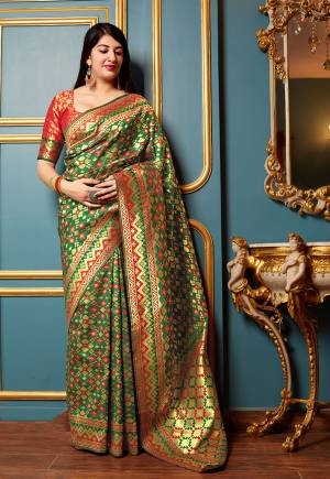 Adorn A Proper Traditional Look Wearing This Designer Silk Based Saree In Green Color Paired With Contrasting Red Colored Blouse. This Saree And Blouse Are Fabricated On Banarasi Art Silk Beautified With Small Weave All Over It. Buy Now.