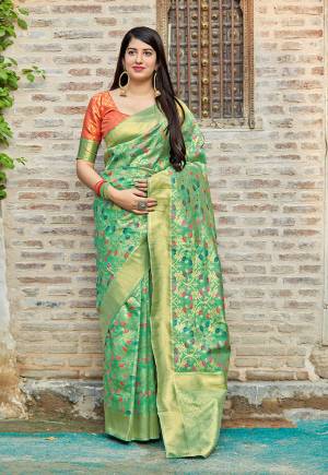 Celebrate This Festive Season With Beauty And Comfort Wearing This Designer Saree In Light Green Color Paired With Contrasting Orange Colored Blouse. This Saree And Blouse Are Fabricated On Banarasi art Silk Beautified With Weave. Its Rich And Fabric Color Will Definitely Earn You Lots of Compliments From Onlookers. 