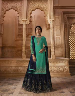 Follow The Sharara Trend With This Very Beautiful Heavy Sharara Suit In Sea Green Colored Top And Bottom Paired With Contrasting Navy Blue Colored Sharara And Dupatta. Its Top Is Fabricated On Satin Georgette Paired With Georgette Sharara, Santoon Bottom And Georgette Fabricated Dupatta. 