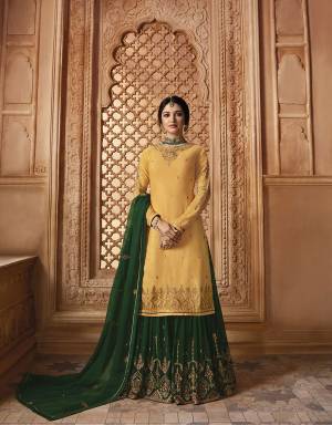 Celebrate This Festive Season Wearing This Heavy Designer Sharara Suit In Musturd Yellow Colored Top Paired With Contrasting Dark Green Colored Lehenga And Dupatta And Also It Comes With A Musturd Yellow Colored Santoon Bottom. Its Embroidered Top IS Fabricated on Satin Georgette Paired With  Embroidered Georgette Sharara And Dupatta. 