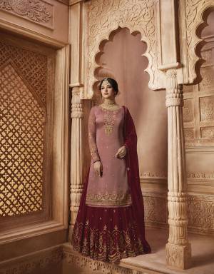 Look Beautiful Wearing This Heavy Designer Sharars Suit In Dusty Pink Colored Top Paired With Contrasting Maroon Colored Sharara And Dupatta And Another Bottom In Dusty Pink Color. Its Top Is Fabricated On Satin Georgette Paired With Two Bottoms In Georgette Sharara And Santoon Bottom. Its Beautiful Color Pallete And Heavy Embroidery Will Definitely Earn You Lots Of Compliments From Onlookers. 