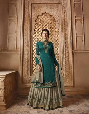 Follow The Sharara Trend With This Very Beautiful Heavy Sharara Suit In Teal Blue Colored Top And Bottom Paired With Contrasting Grey Colored Sharara And Dupatta. Its Top Is Fabricated On Satin Georgette Paired With Georgette Sharara, Santoon Bottom And Georgette Fabricated Dupatta. 