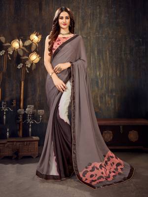 Here Is A Pretty Comfortable And Light Weight Saree In Grey And Pink Color Fabricated On Chiffon. Its Blouse Is Beautified With Prints All Over And The Saree Has A Printed Patch Over The Pallu. 