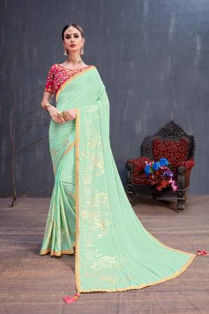 This Season Is About Subtle Shades And Pastel Play, So Grab This Very Pretty Designer Saree In Pastel Green Color Paired With Contrasting Rani Pink Colored Blouse. This Rubber Foil Printed Saree Is Georgette Based Paired With Art Silk Fabricated Embroidered Blouse. 