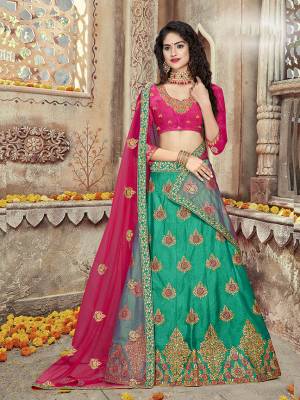 Get Ready For The Upcoming Festive And Wedding Season Wearing This Heavy Designer Silk Based Lehenga Choli In Dark Pink And Green Color, Its Blouse And Lehenga Are Fabricated on Art silk Paired With Net Fabricated Dupatta. 