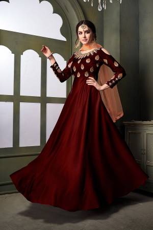 Grab This Very Beautiful Heavy Designer Floor Length Suit In Maroon Color Paired With Contrasting Peach Colored Dupatta. Its Top Is Fabricated On Satin Silk Paired With Santoon Bottom Paired With Net Fabricated Dupatta. It Is Beautified With Embroidery With Over The Yoke And Sleeve. Buy Now.