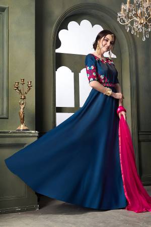 Here Is A Very Pretty Designer Floor Length Suit In Blue Color Paired With Contrasting Dark Pink Colored Dupatta. Its Embroidered Top Is Fabricated On Satin Silk Paired With Santoon Bottom And Net Fabricated Dupatta. Buy Now.