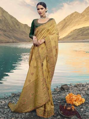 Flaunt Your Rich And Elegant Taste Wearing This Heavy Designer Saree In Beige Color Paired With Dark Green Colored Blouse. Its Rich color Pallete And Silk Fabricated Will Give You A Look Like Never Before.