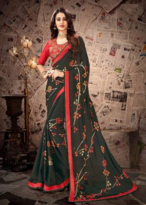 Celebrate This Festive Season In A Traditional Color Pallete With This Designer Saree In Dark Green Color Paired With Contrasting Red Colored Blouse. This Saree Is Fabricated On Satin Georgette Paired With Cotton Slub Embroidered Blouse. 