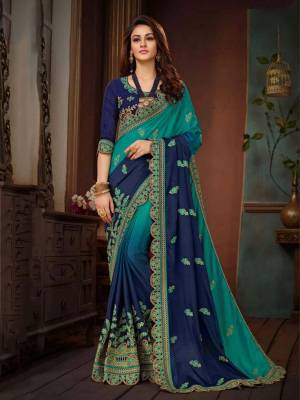 Shaded Saree Can Never Go Out Of Style, Grab This Saree In Shades Of Blue Paired With Navy Blue Colored Blouse. This Saree And Blouse Are Silk Based Beautified With Attractive Embroidery. 