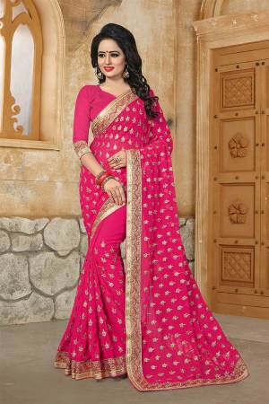 Here Is A Very Pretty Designer Saree For The Upcoming Festive And Wedding Season In Rani Pink. This Saree And Blouse are Fabricated On Georgette Beautified With Butti All Over With Jari Embroidery Highlighted With Stone And Pearl Work. 