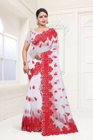 Here Is A Subtle And Simple Color with This Heavy Embroidered White Colored Saree Paired with White Colored Blouse. This Saree And Blouse are Beautified With contrasting Red Colored Resham Embroidery And Moti Work. 