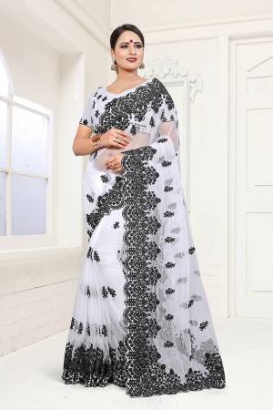 Here Is A Subtle And Simple Color with This Heavy Embroidered White Colored Saree Paired with White Colored Blouse. This Saree And Blouse are Beautified With contrasting Black Colored Resham Embroidery And Moti Work. 