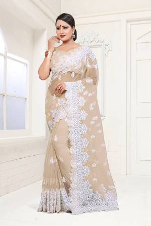 Flaunt Your Rich And Elegant Taste In This Heavy Designer Beige Colored Saree. This Pretty Saree And Blouse Are Fabricated On Net Which Comes A Satin Inner. It IS Beautufied With Heavy Resham Embroidery In White Colored Thread. Buy This Lovely Piece Now.