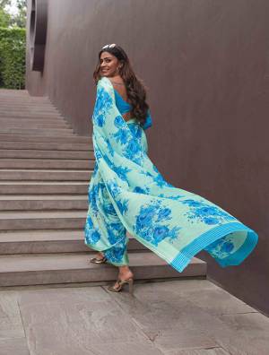 For Your Semi-Casuals, Grab This Pretty Saree In Pastel Green And Blue Color Paired with blue Colored Blouse. This Saree Anf Blouse Are Fabricated On Soft Line Beautified With Bold Floral Prints All Over It. 