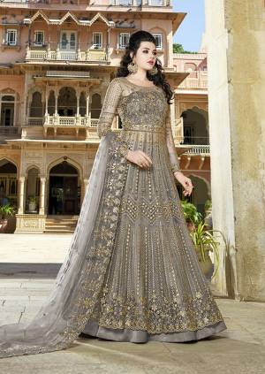 Here Is An Elegant Girly Shade With This Heavy Designer Floor Length Suit In Dark Grey Color. Its Top And dupatta are Net Based Beautified With Heavy Embroidery Paired With Satin Fabricated Bottom. 