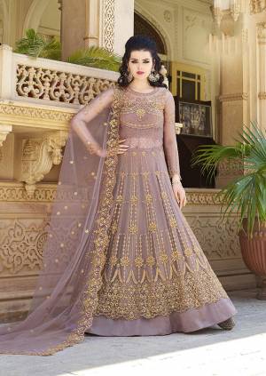 New And Unique Shade In Purple Is Here With This Heavy Designer Floor Length Suit In Mauve Color. Its Heavy Embroidered Top And Dupatta Are Fabricated On Net Paired With satin Fabricated Bottom. All Its Fabrics Are Light Weight And Ensures Superb Comfort All Day Long. 