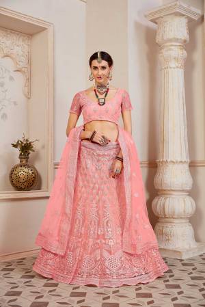This Wedding Season Be The Most Sensational Diva Wearing This Heavy Designer Lehenga Choli In Pink Color. This Pretty Blouse, Lehenga And Dupatta Are Fabricated On Net Beautified With Tone To Tone Coding And Resham Embroidery With Stone Work. Buy This Designer Piece Now.