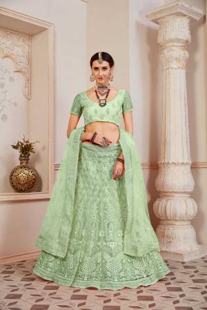 This Wedding Season Be The Most Sensational Diva Wearing This Heavy Designer Lehenga Choli In Light Green Color. This Pretty Blouse, Lehenga And Dupatta Are Fabricated On Net Beautified With Tone To Tone Coding And Resham Embroidery With Stone Work. Buy This Designer Piece Now.