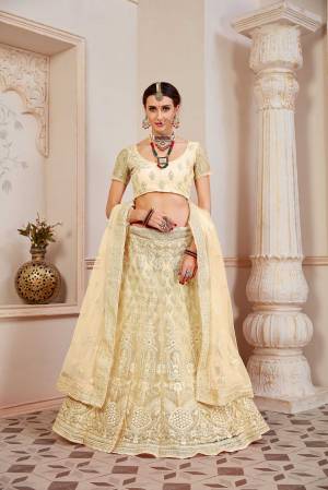 This Wedding Season Be The Most Sensational Diva Wearing This Heavy Designer Lehenga Choli In Pale Yellow Color. This Pretty Blouse, Lehenga And Dupatta Are Fabricated On Net Beautified With Tone To Tone Coding And Resham Embroidery With Stone Work. Buy This Designer Piece Now.