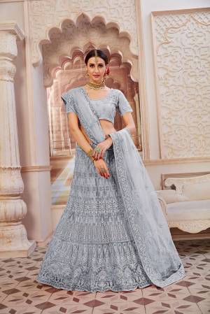 This Wedding Season Be The Most Sensational Diva Wearing This Heavy Designer Lehenga Choli In Grey Color. This Pretty Blouse, Lehenga And Dupatta Are Fabricated On Net Beautified With Tone To Tone Coding And Resham Embroidery With Stone Work. Buy This Designer Piece Now.