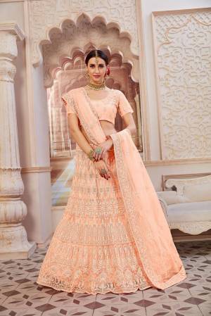This Wedding Season Be The Most Sensational Diva Wearing This Heavy Designer Lehenga Choli In Peach Color. This Pretty Blouse, Lehenga And Dupatta Are Fabricated On Net Beautified With Tone To Tone Coding And Resham Embroidery With Stone Work. Buy This Designer Piece Now.