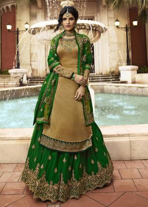 Celebrate This Festive And Wedding Season With This designer Indo-Western Lehenga Suit In Dark Beige Colored Top Paired With Contrasting Green Colored Lehenga And Dupatta. Its Top Is Satin Georgette Based Paired With Net Fabricated Lehenga And Dupatta.