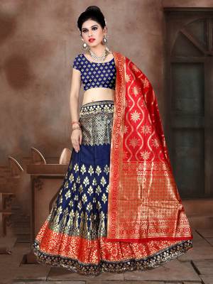 This Festive Season Have A Proper Traditional Look Wearing This Silk Based Lehenga Choli In Navy Blue Color Paired With Contrasting Red Colored Dupatta. This Lehenga Choli Is Fabricated On Banarasi Jacquard Silk Beautified With Weave All Over. 