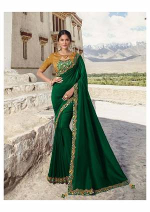 Get Ready For The Upcoming Festive And Wedding Season With This Designer Saree In Dark Green Color Paired With Contrasting Musturd Yellow Colored Blouse. This Saree Is Fabricated On Soft Silk Paired With Satin Silk And Art Silk Fabricated Blouse. Its Color Pallete And Rich Fabric Will Definitely Earn You lots Of Compliments From Onlookers. 